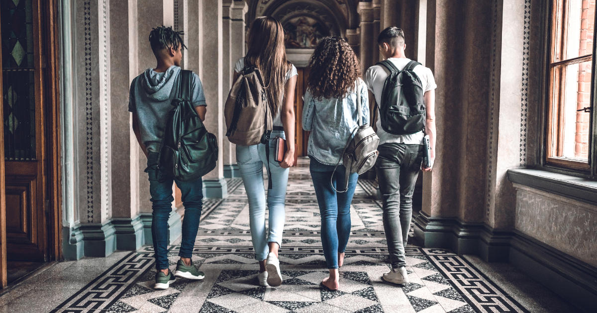 A group of college age young adults walking down a nice hallway to show Transitioning from College to the Workforce: Why You Need a Career Coach